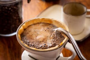 Freshly roasted coffee beans in a scoop showing rich colour and texture